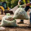 Worker lifting heavy-duty compostable bag filled with gravel at a construction site